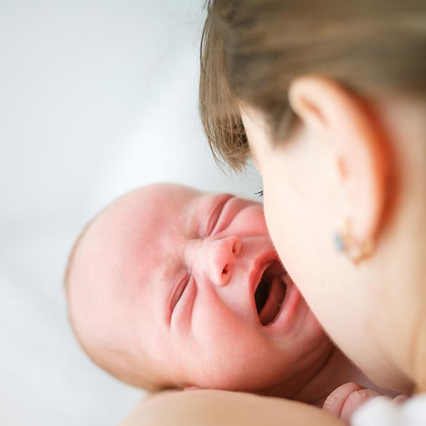 Newborn baby sleeping on mother's shoulder